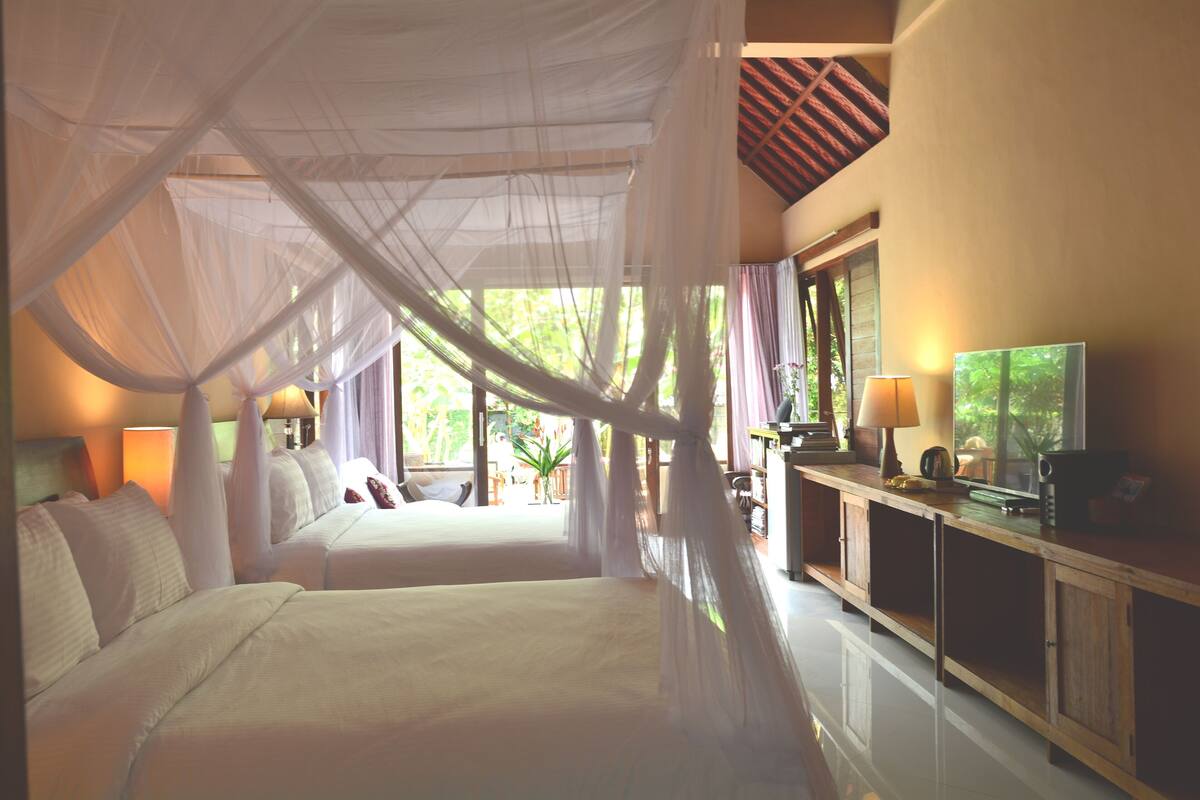 A bedroom with two beds, a TV, and a cabinet.