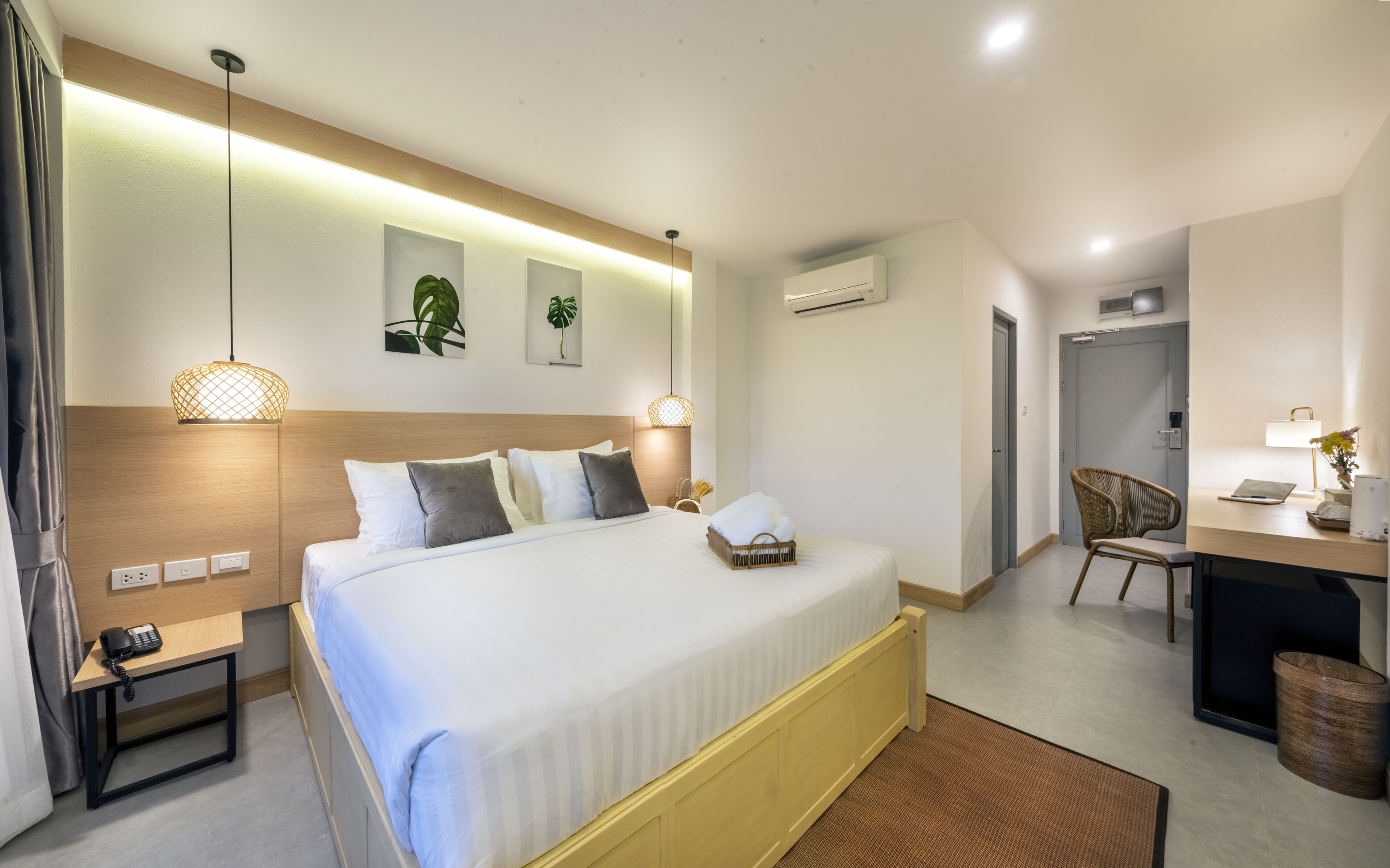Camera d'albergo moderna con un letto grande, comodini, una scrivania e una sedia.