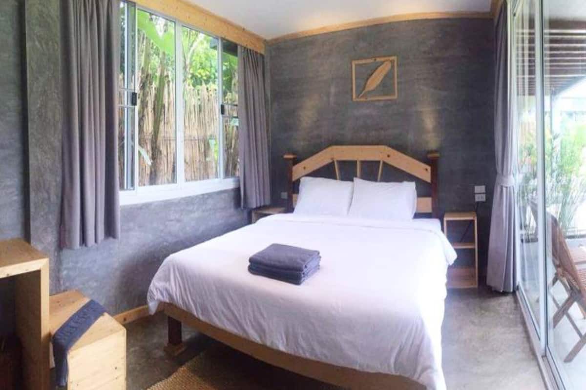 Un dormitorio con una cama grande, cabecera de madera y una ventana con cortinas.
