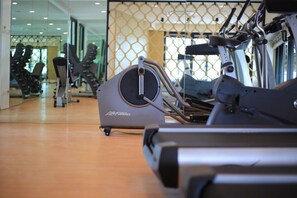 A gym with treadmills and exercise equipment, a mirrored wall, and a wooden floor. - Varinah Resort (Sam Roi Yot)