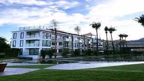 A multi-story hotel with balconies, a swimming pool, and palm trees. - Varinah Resort (Sam Roi Yot)