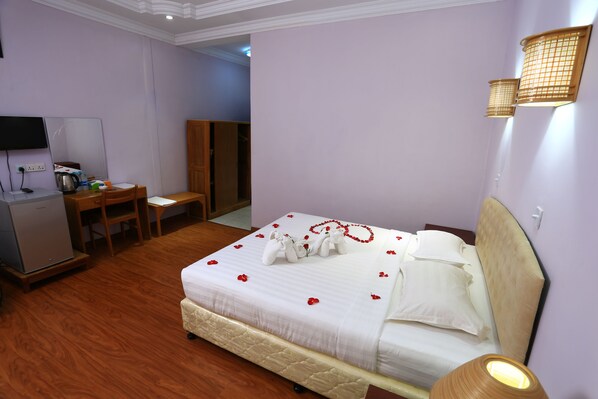 A hotel room with a bed, a desk, a television, and a wardrobe. - The Floral Breeze Wun Zin Hotel (Meiktila)