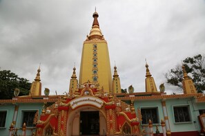 A temple with a tall central tower, ornate decorations, and multiple smaller spires. - The Floral Breeze Wun Zin Hotel (Meiktila)