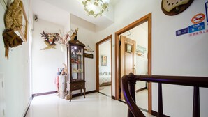 A hallway with a wooden railing, a traditional cabinet with glass doors, and a 'No Smoking' sign. - Tainan Anping Bailuwan House (Tainan)