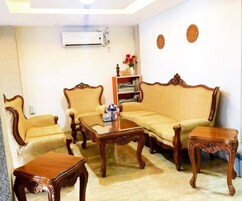 Una sala de estar con un sofá, dos sillones, una mesa de centro y una estantería.