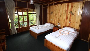 Una habitación con dos camas de madera, un escritorio de madera y una ventana con cortinas.