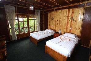 A room with two wooden beds, a wooden desk, and a window with curtains. - The Floral Breeze Hotel Mt.Victoria (Kanpetlet)