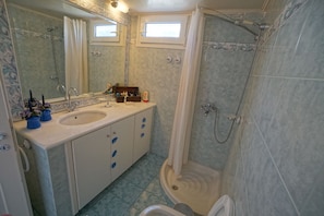 A bathroom with two sinks, a shower, and a toilet. - Seafarer's Suite (Delphi)