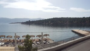 Vista al lago con una playa que incluye sombrillas y sillas reclinables.