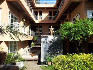 Stunning multi-level building with a central staircase and lush greenery surroundings.