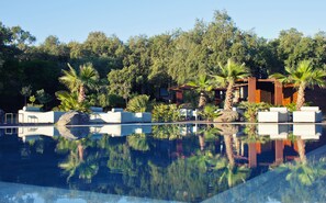 A pool area with lounge chairs and palm trees. - Vallegrande Nature Resorts (Cefalù)