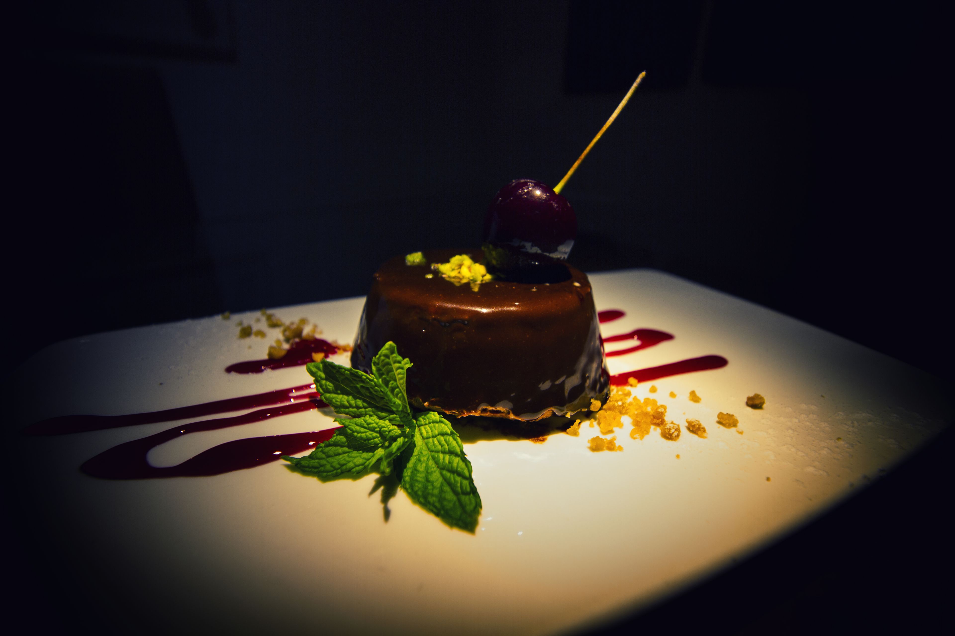 A dessert on a white plate with a dark background.