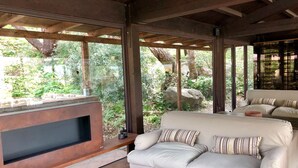 A modern living room with a large flat-screen TV, a beige sofa with striped pillows, and a glass coffee table. - Vallegrande Nature Resorts (Cefalù)