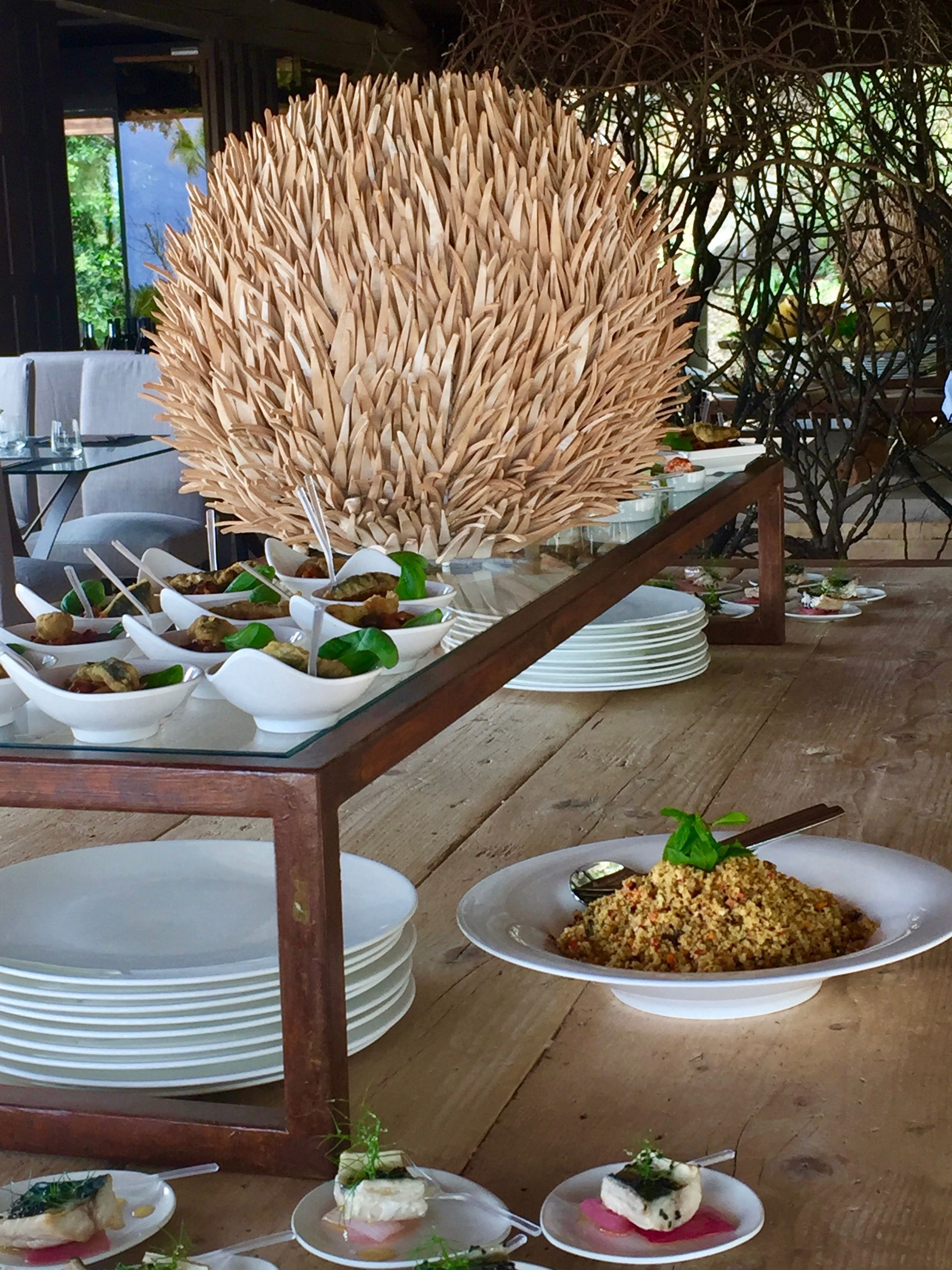 A dining table with multiple white plates and bowls containing various dishes, set on a wooden floor.