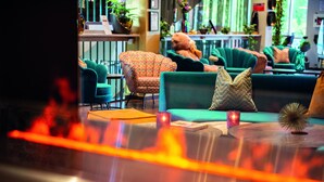 A cozy lounge area with comfortable seating, a small table, and decorative items. - Skogshem & Wijk (Lidingo)