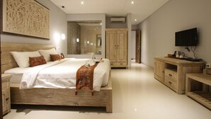 A modern bedroom with a wooden bed, a TV, and a wardrobe. - Batu Empug Ubud Cottages (Ubud)