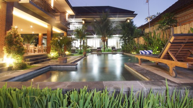 A modern resort with a swimming pool, outdoor seating, and a well-lit patio area. - Batu Empug Ubud Cottages (Ubud)