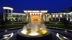 A hotel entrance with a fountain in the foreground, a well-lit facade, and a symmetrical garden layout. - Kylin villa (Shenzhen)