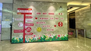 A wall with directional signs and messages in a foreign language, a smiley face, and a flower border. - Green Lemon Tree International Apartment - Beijing Road Jiedeng Metropolis Branch (Guangzhou)