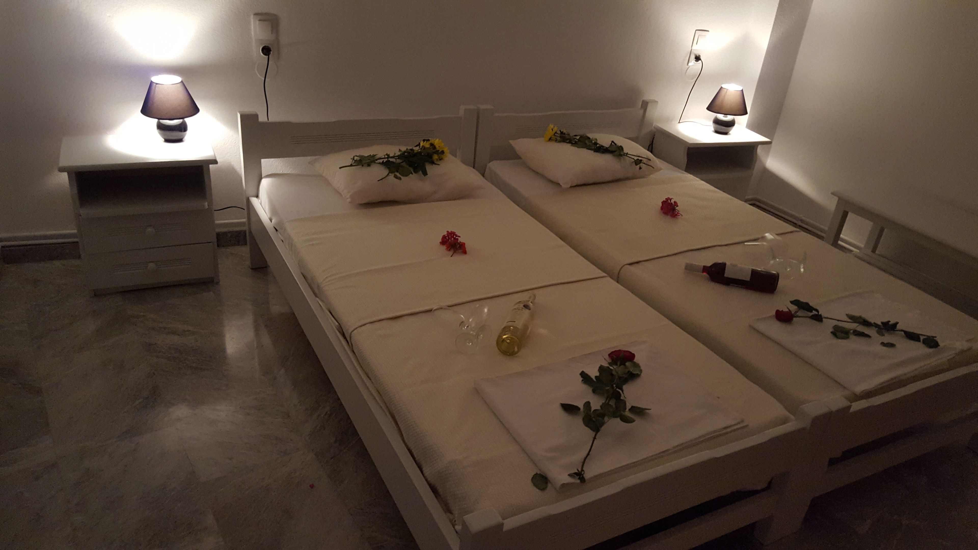 A room with a bed, two bedside tables, and a lamp on each table.