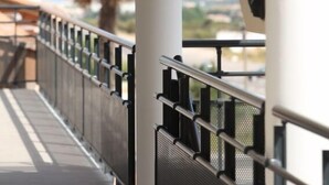 A balcony with a metal railing overlooking a coastal landscape. - Hôtel Restaurant les Pielettes (Le Rove)