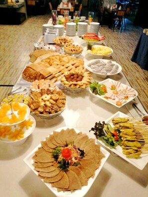 Una mesa de buffet con diversos alimentos y platos.