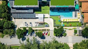 Luchtbeeld van een resort met zwembad, strand en parkeerplaats.