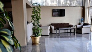 Un vestíbulo moderno con un conjunto de sofás, una mesa de centro y una planta en maceta.