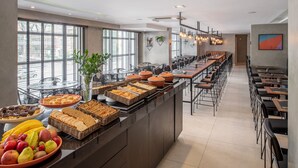 Een buffet met diverse gerechten en een lange toonbank met zitplaatsen.
