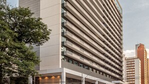 A modern hotel with a prominent "INTERCITY" sign, a covered entrance, and a series of balconies.