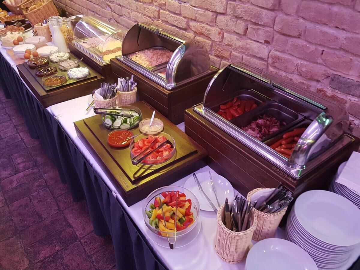 A buffet setup with various food items and utensils.