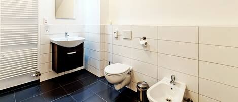 Un baño moderno con inodoro, bidé y lavamanos.