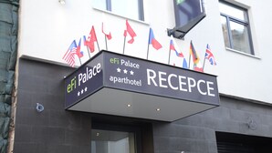Ein Schild an der Hotelrezeption mit Flaggen und dem Namen "eFi Palace Apart Hotel".