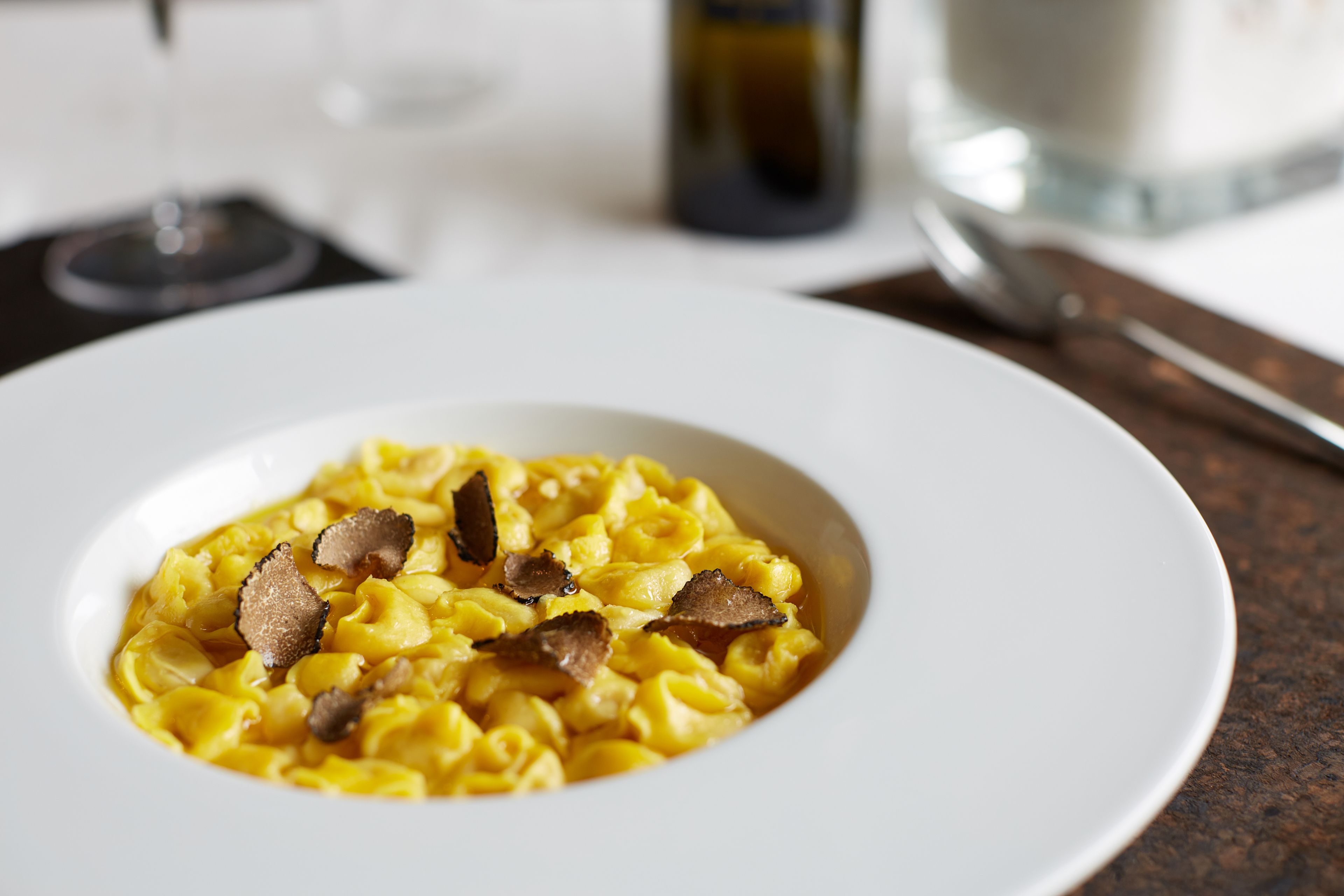Un plato blanco con pasta y trufas.