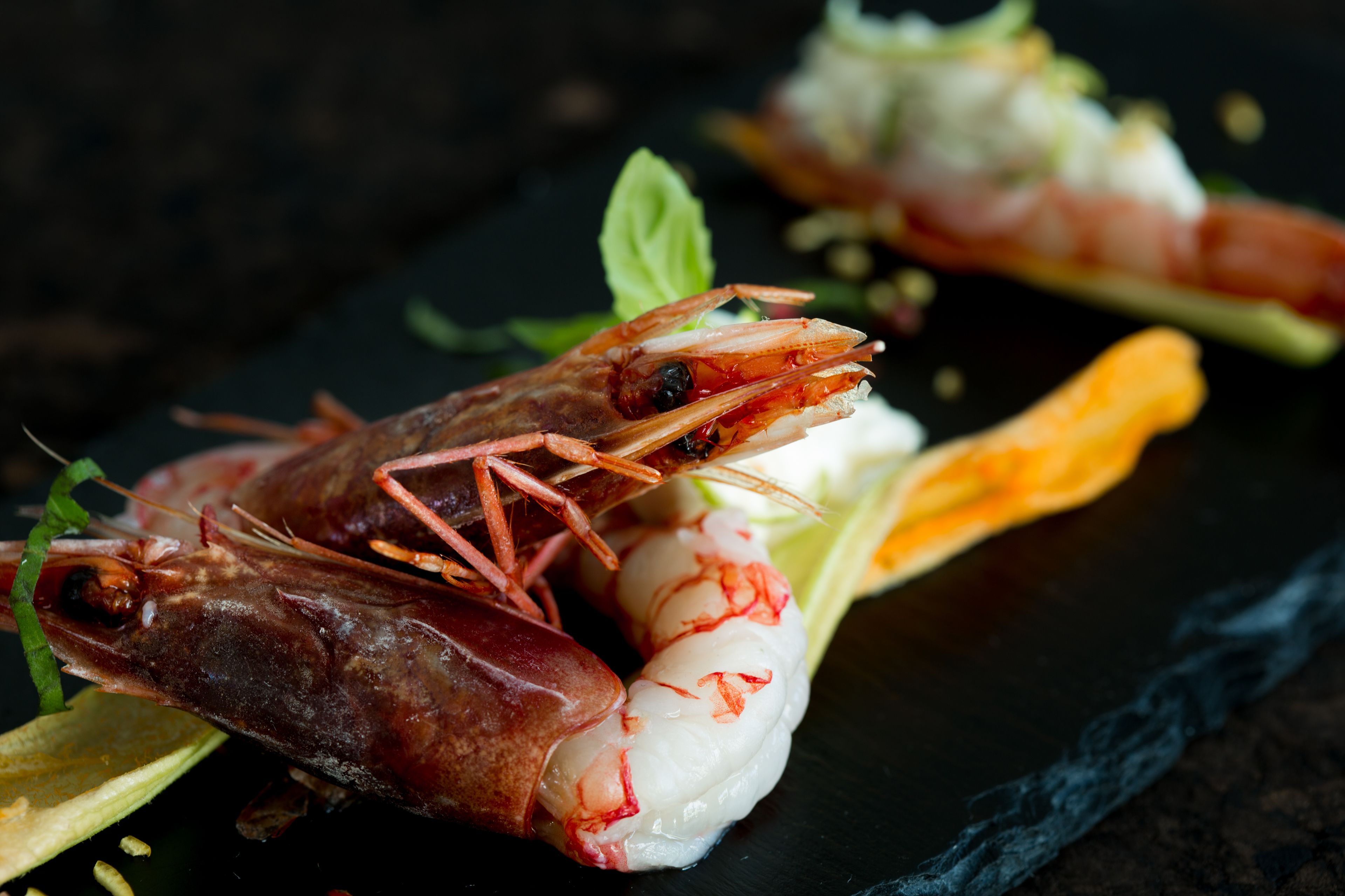 Gros plan d’un plat contenant des crevettes et du riz blanc, servi dans une assiette sombre.