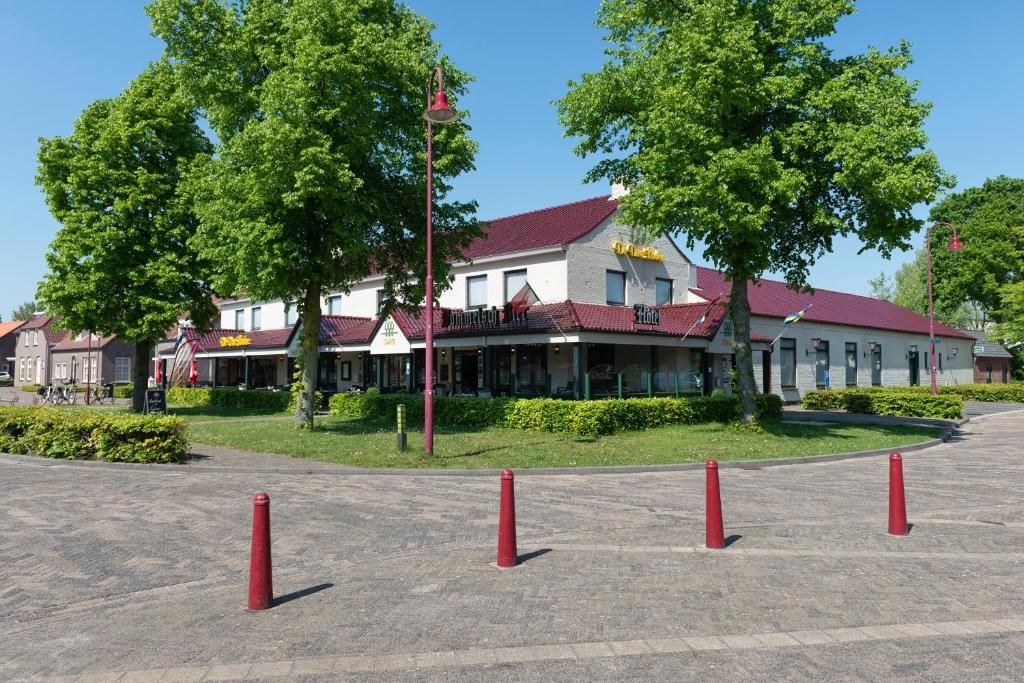 A hotel with a red roof, a balcony, and a flag.