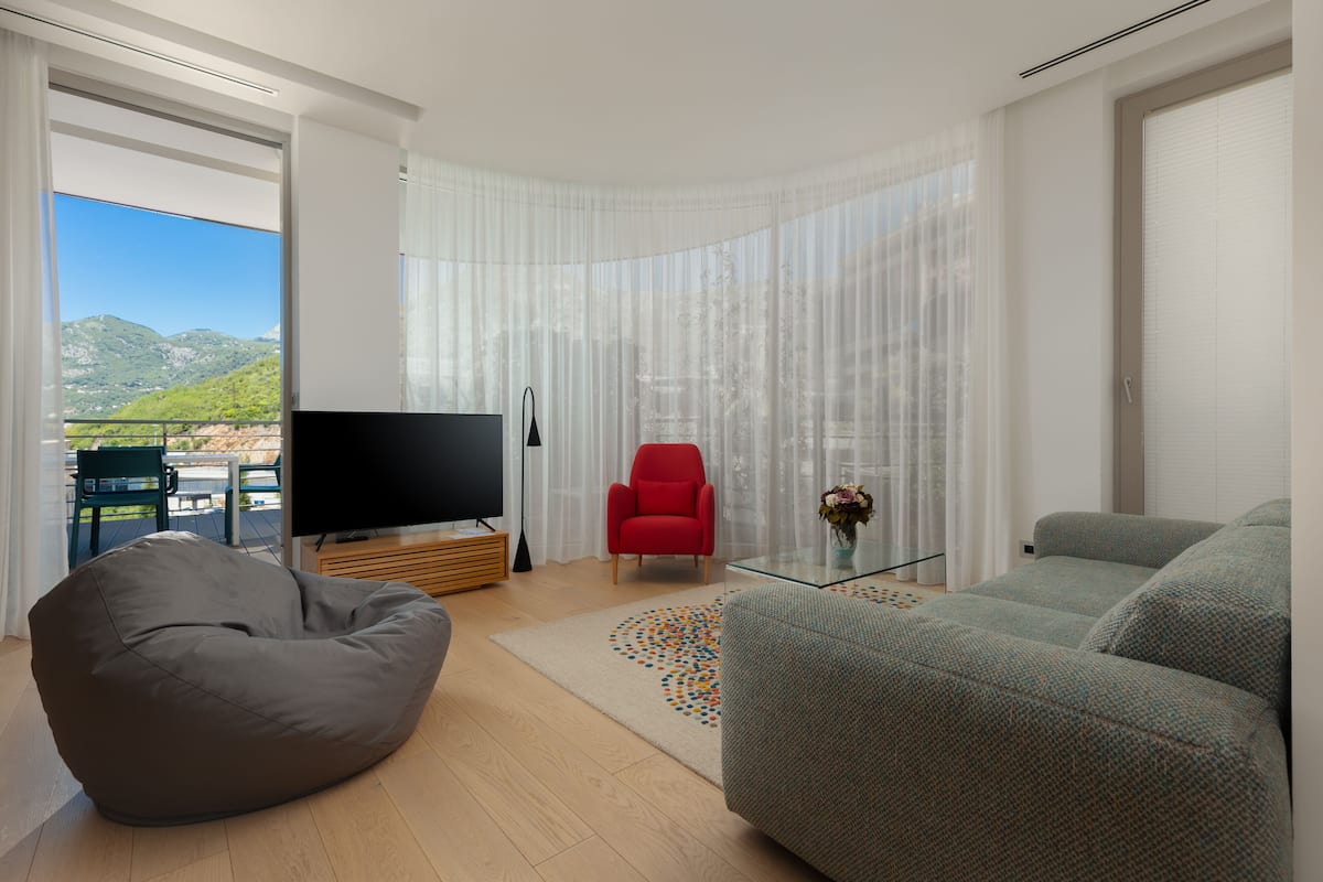 Appartamento, 1 camera da letto, vista giardino | Area soggiorno | TV a schermo piatto