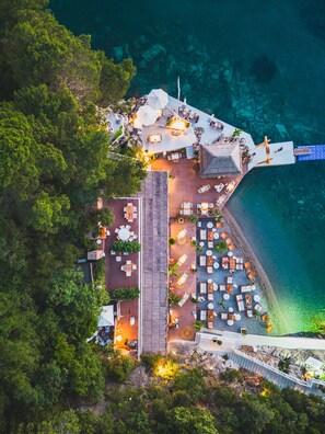 An aerial view of a resort with outdoor seating areas, a pool, and a beach. - Dukley Hotel & Resort (Budva)