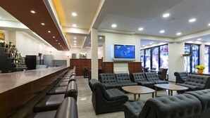 A modern bar area with seating and a television screen. - Sterling Hotel (Belgrade)