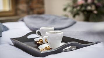 Un plateau avec deux tasses blanches et une petite assiette de noix.