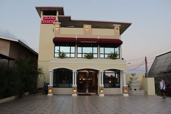 Un hôtel dont l’enseigne, bien visible, porte l’inscription « Grand Diamond Hotel ».