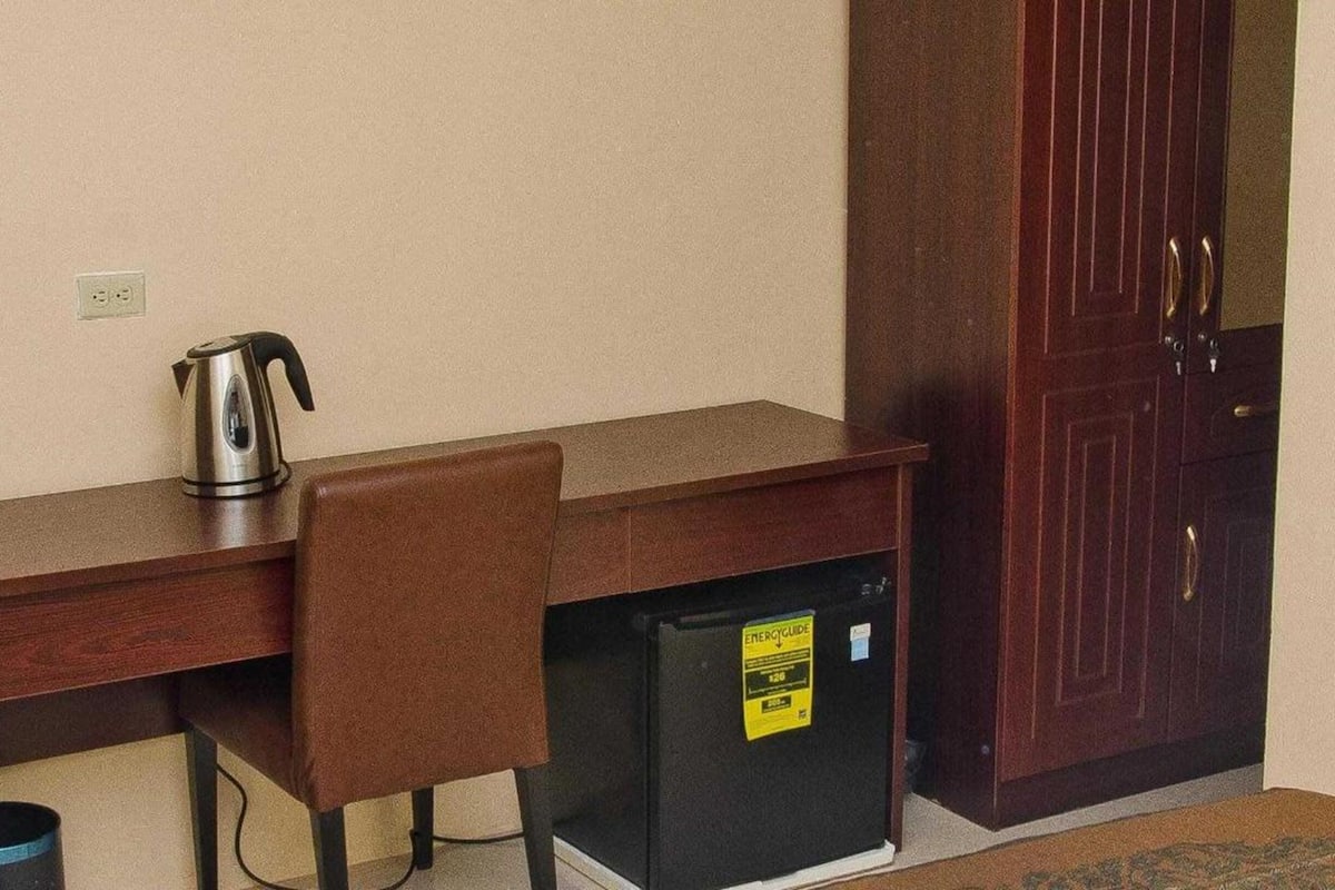 Une petite cuisine équipée d’une machine à café, d’un réfrigérateur et d’un placard.