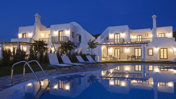 A modern villa with a swimming pool, outdoor seating, and a well-lit entrance. - Aqua Breeze Villas Naxos (Naxos)