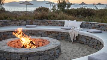 Na praia, areia branca, espreguiçadeiras, guarda-sóis