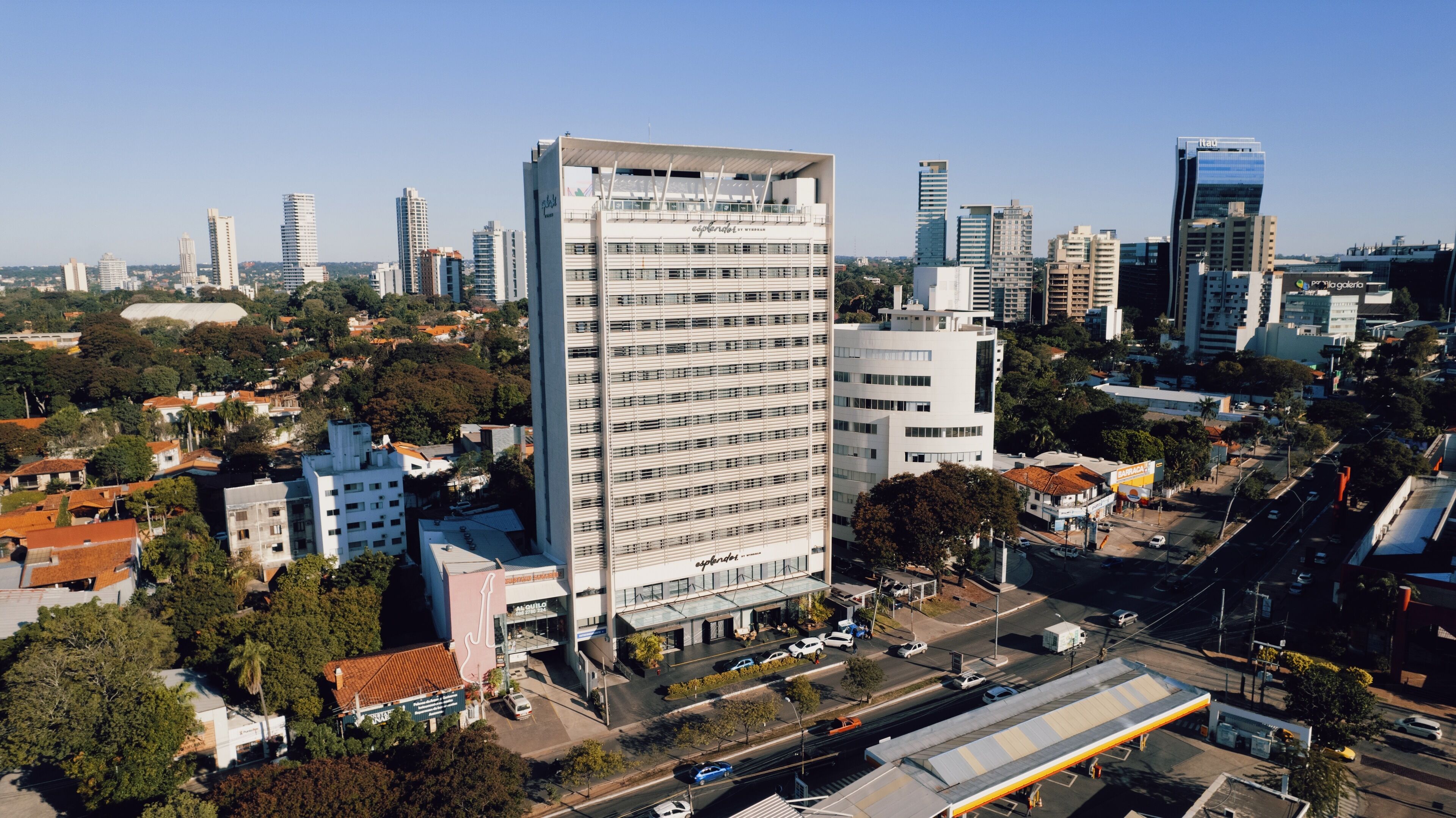 A high-rise building with multiple floors, surrounded by other buildings and greenery.