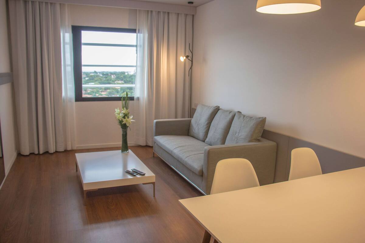 Un salon moderne avec un canapé, une table basse et une table à manger.