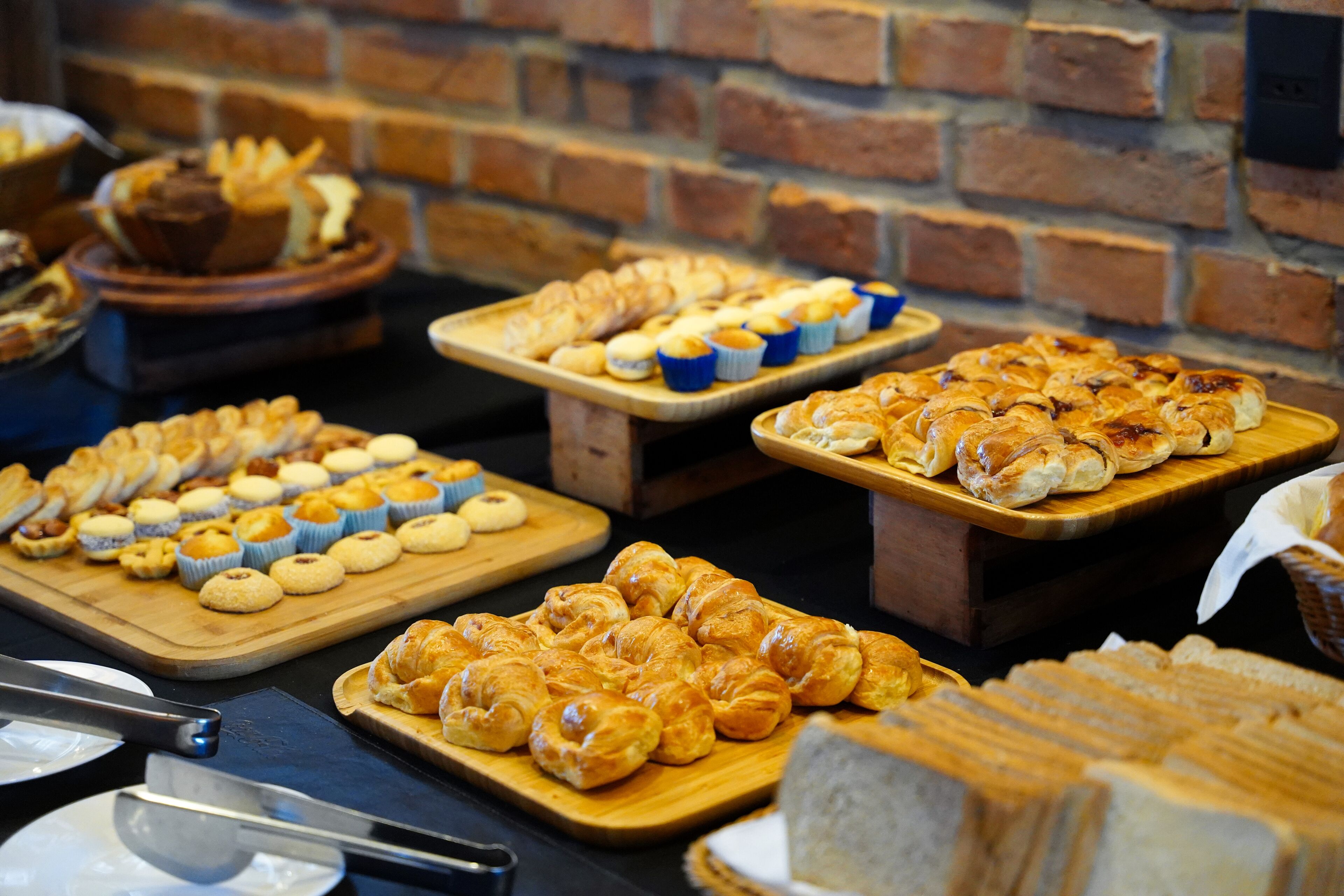 Buffet com diversos produtos de panificação, incluindo doces e pão.