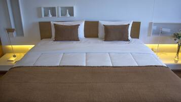 A neatly made bed with a brown blanket and two pillows, a bedside table with a lamp, and a wall-mounted shelf with decorative items.