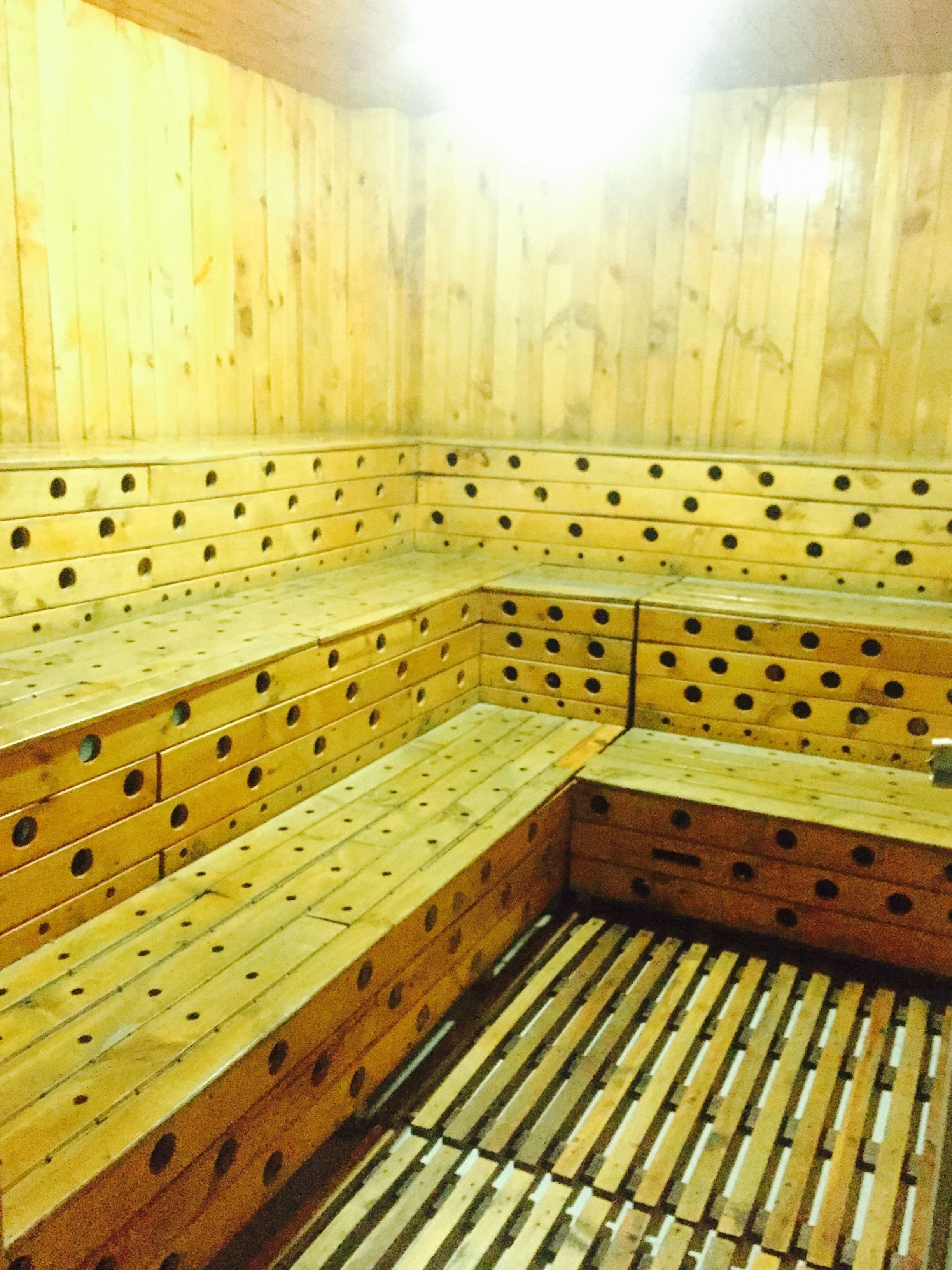Una sauna con bancos de madera y suelo de tablones.
