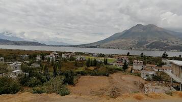 Un pueblo costero con edificios cerca del agua y una montaña al fondo.